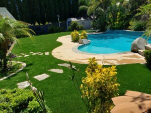 backyard landscaped around pool using artificial grass